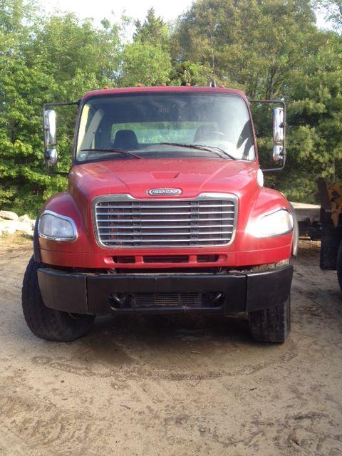Front view of a red 2008 Freightliner M2106 cab and chassis truck showing grille, headlights, bumper, and side mirrors.