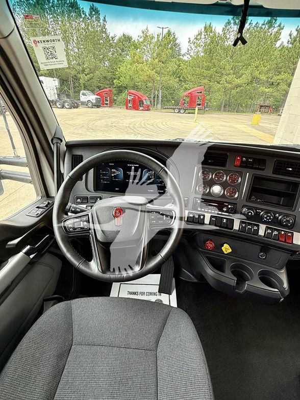 Interior of a 2026 Kenworth T880 cab showing steering wheel, dashboard with gauges and controls, and front passenger seat.