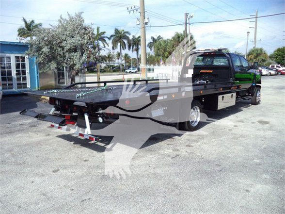 2023 International CV truck in a lot with flatbed tow bed and multiple decals; VIN 1HTKTSWK3PH419804; stock J19804; category Tow; type Trucks; new