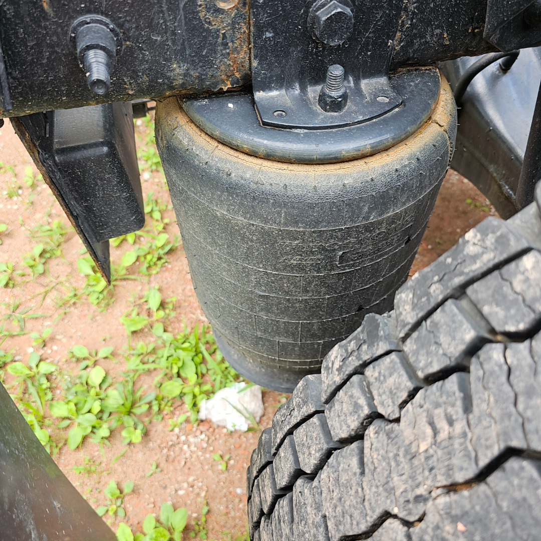 Axle hub and air ride suspension coil cylinder on a 2020 International LT truck, showing a large rubber air spring and nearby dual tires.