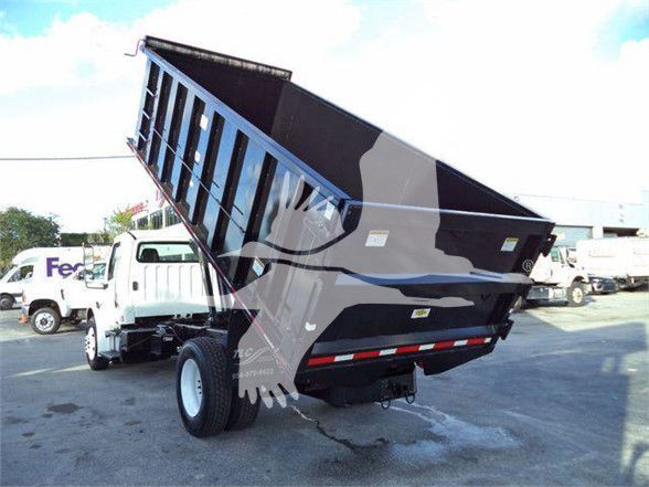 Dump bed truck with Freightliner Business Class M2 106 style, dump bed raised. Visible text on truck includes likely branding and license plate area, but no legible alphanumeric text readable due to image quality.