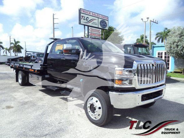 No text visible on the vehicle exterior; International CV tow truck with black body and white front grille in a dealership lot.