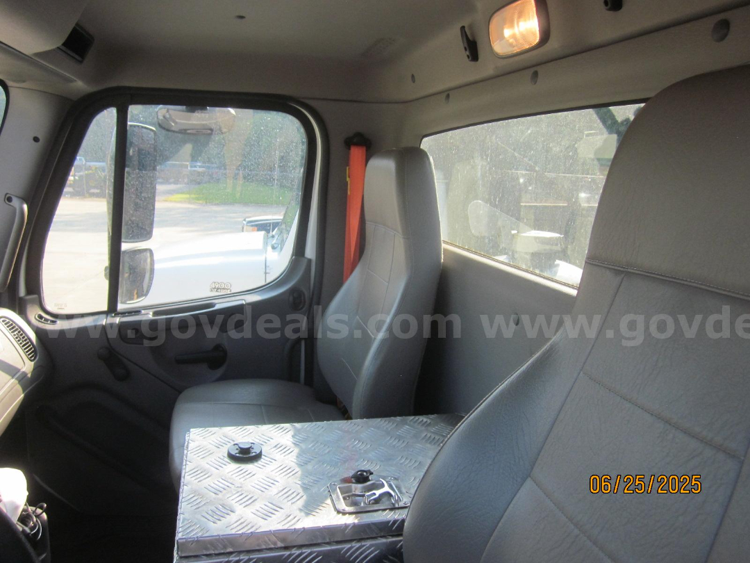 Cab interior of a 2017 Freightliner Vactor Truck showing front seat and diamond-plate toolbox with a round access cap.