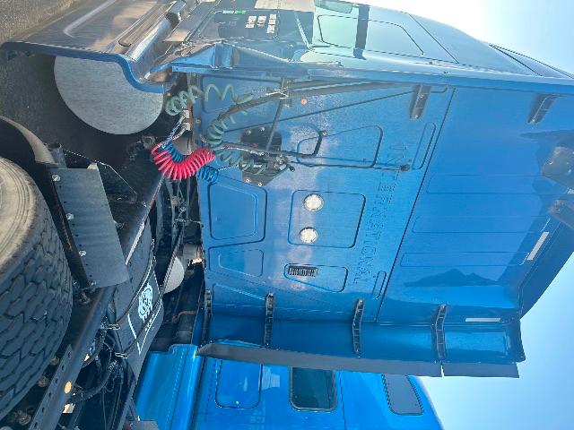 Blue International Prostar truck cab interior/side showing under-hood area and driver door with wiring and components visible.