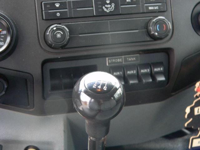 Transmission shifter with six-speed pattern in Ford F-750 interior, dashboard controls visible.