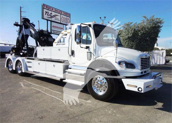 Tow truck with a white Freightliner Business Class M2 106 featuring a heavy-duty boom and multiple storage compartments.