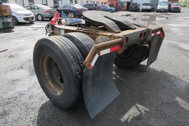 Trailer dolly with dual rear tires and mud flaps showing rear deck and safety reflectors.
