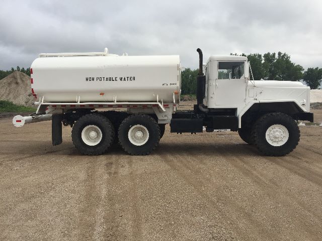 Six-wheeled white military water tanker truck with a large cylindrical tank labeled WPO? POTABLE WATER, attached to a long chassis and a square cab.