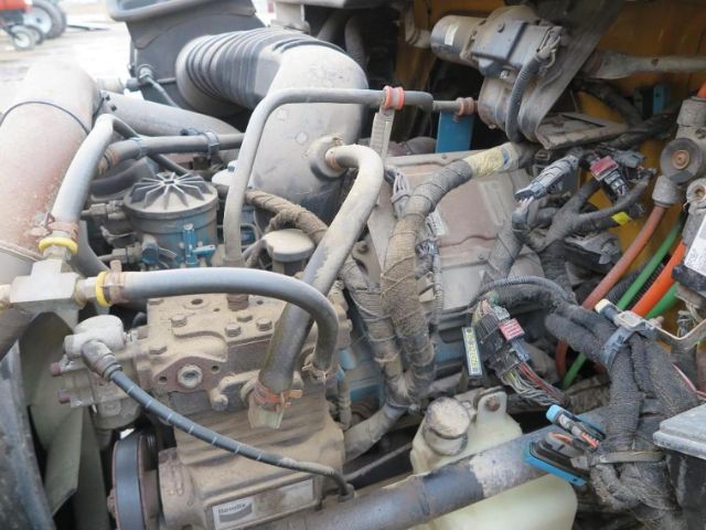 Vehicle engine bay showing VT365 engine with various hoses, wiring harnesses, and metal components visible.