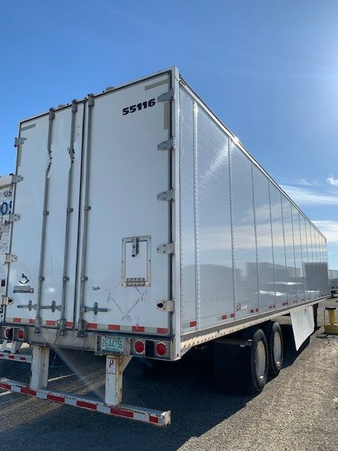 Rear and side view of a white box trailer with silver reflective panels. Visible text: '55116' on rear door, bumper lights, license plate area, and wheel wells. VIN provided in context but not on image.