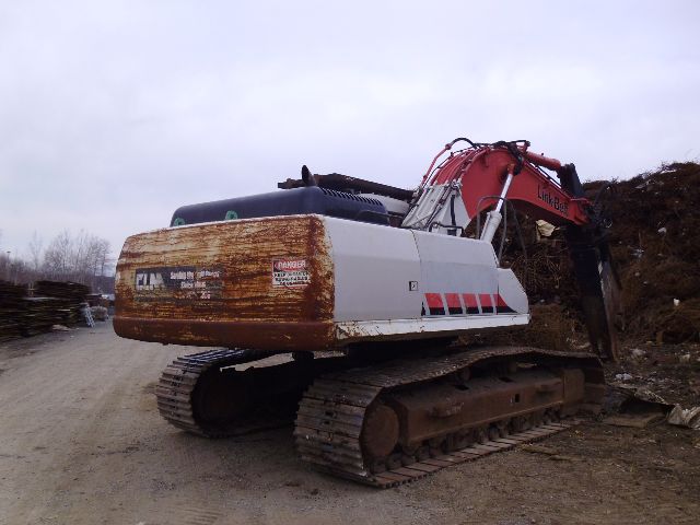 2008 Link Belt 330LX excavator with rusty rear counterweight and red boom in a scrapyard.