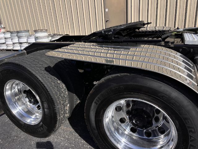 Peterbilt 579 daycab tractor rear wheel area with aluminum fenders and dual rear tires.