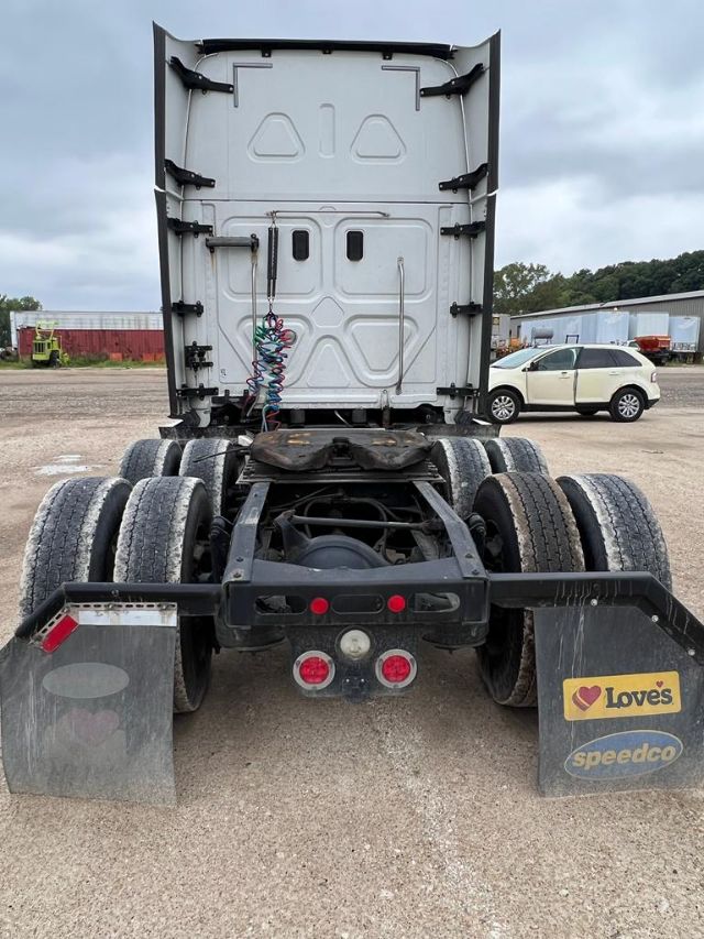 Freightliner Cascadia rear view showing fifth wheel and dual rear axles with mud flaps and wiring harness.