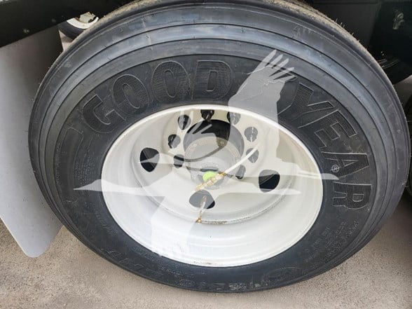 Goodyear tire mounted on a white wheel of a trailer with Goodyear branding visible.