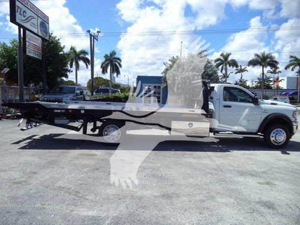 2024 Ram 5500 SLT tow truck with flatbed chassis in dealership lot.
