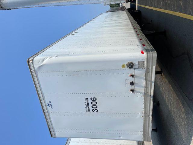 Rear-left perspective of a white Hyundai trailer with 3006 number and small utility gauges near bumper.