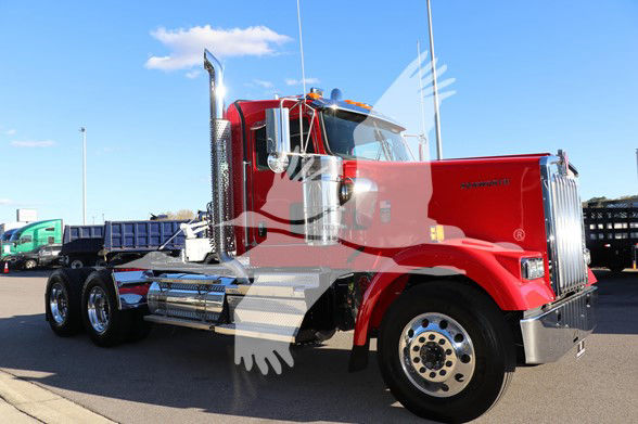 Kenworth W900L conventional daycab truck in red with chrome exhaust stacks and dual rear axles.
