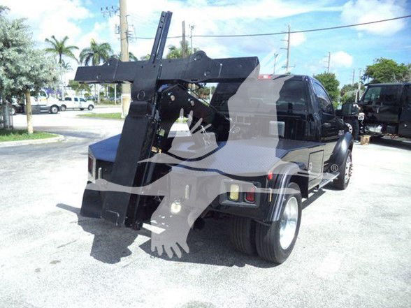 Tow truck with a large hydraulic lift attached in the bed. Visible text includes stock number and vehicle details on the listing: Stock Number T45243FM. Category Tow, Type Trucks, NewUsed Used.
