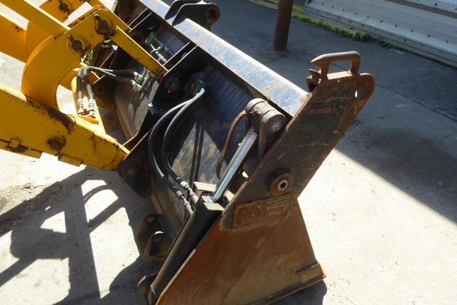 Backhoe attachment with hydraulic cylinders and bucket linkage showing bucket edge and mounting pin on a Massey Ferguson 50HX machine.