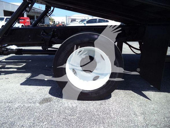 Wheel and undercarriage of a 2015 Ford F650 tow truck showing the rear wheel and suspension components.