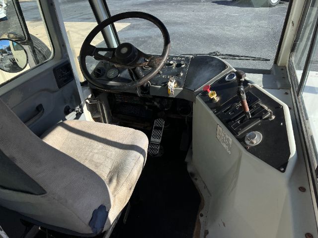 Cab interior of a 2005 Kalmar Ottawa yard truck showing steering wheel, pedals, and control console with switches.