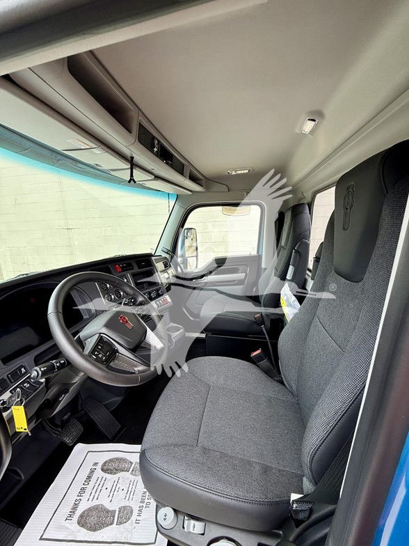Kenworth T880 truck interior showing steering wheel, dashboard, and front seats. Visible text includes nothing legible beyond generic vehicle interior features.