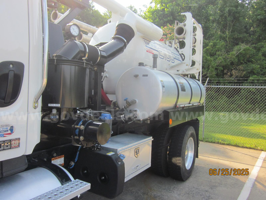 Truck side view of a 2017 Freightliner Vactor vacuum truck showing cylindrical stainless fuel/rehydration tank, black hydraulic components, and white cab with side mirror.