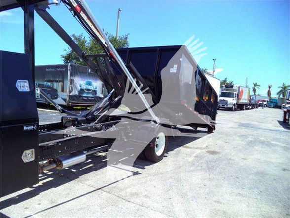 Isuzu NRR refuse truck trailer with hydraulic lift and dump body, side view showing rear wheel and cargo bed.