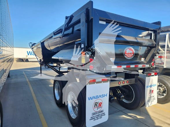 Dump trailer with dual rear axles, blue frame, and white mud flaps. Visible text includes WABASH on mud flaps and rear, RR logo, and safety decals. Snap shows tail area and hydraulic components.