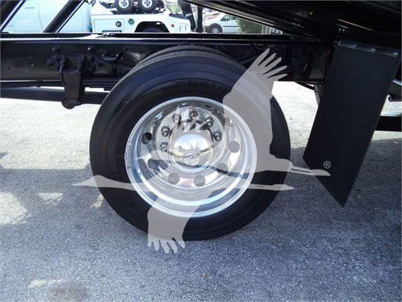 Ford F750 wheel and undercarriage showing steel rim, tire, and portion of chassis in a tow truck configuration.