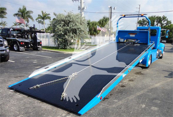 Tow truck flatbed in blue with extended ramp and chains, Peterbilt 337 context image.