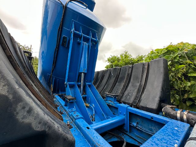 Blue Mack GU713 truck cab frame and engine bay area with black hoses and metal chassis visible.