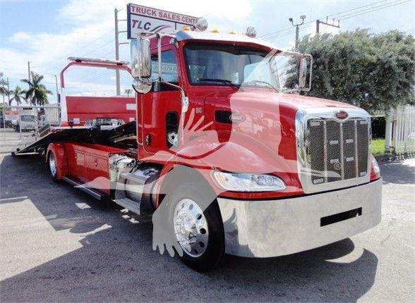 Peterbilt 337 tow truck front-right view with red cab and flatbed, chrome bumper and grille, large side mirrors.