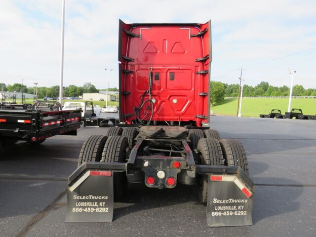 Red Freightliner Cascadia Evolution tractor cab rear view showing dual rear wheels and mudflaps with contact numbers.