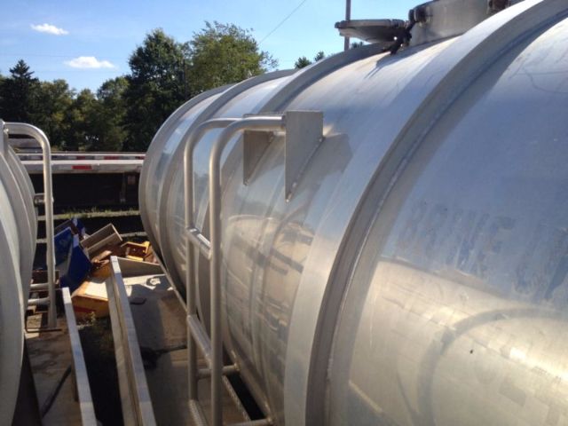 Vacuum tank truck side view showing cylindrical aluminum tank with access ladder and top fittings.