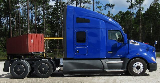 Kenworth T680 cab and chassis with a blue sleeper cab and a red container on the flatbed trailer.