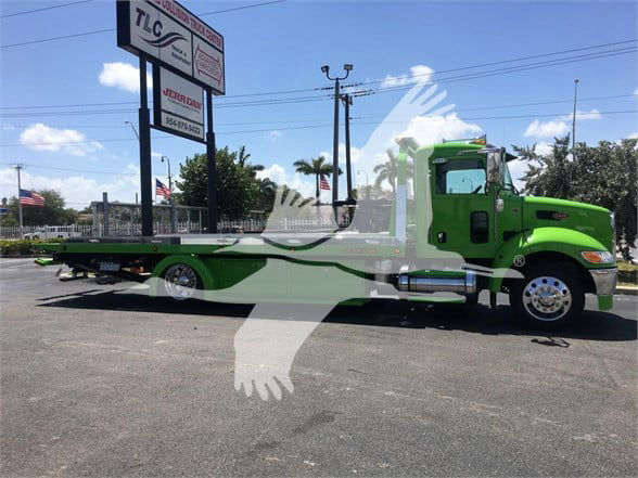 2022 Peterbilt 337 tow truck in green, side view showing flatbed with wheelbase and cab; stock number J52310 visible in listing context.