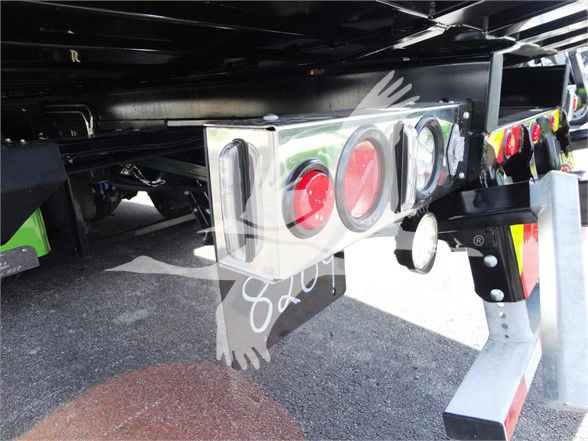 Rear view showing a metal bumper with three circular red reflectors and a white rectangular housing. Part of trailer hitch and undercarriage visible.