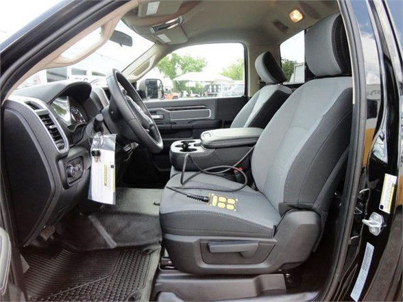 Interior of a 2024 Ram 4500 HD SLT crew cab showing front seats, steering wheel, dashboard, and center console.