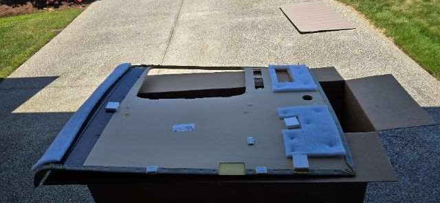 Volvo 760 truck sleeper part large gray panel with foam padding and cutouts on a driveway.