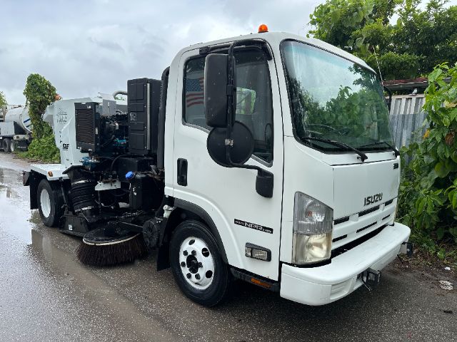 Isuzu NPR-HD sweeper truck in white, side view showing large cab and rotating brushes at rear.