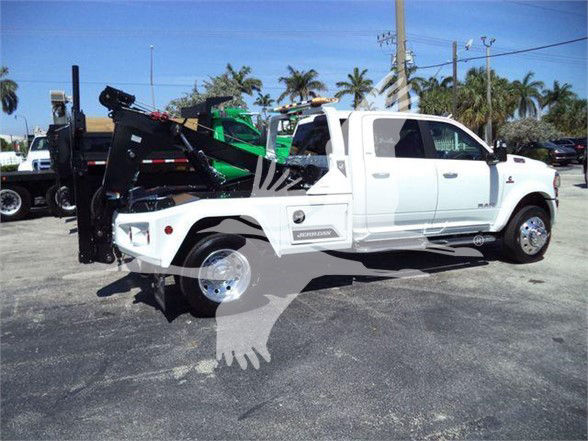 Ram 5500 tow truck in white with flatbed and hydraulic lift, side view showing Ram badge and model details.