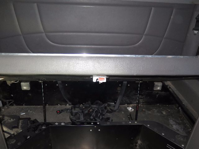 Peterbilt 388 truck interior dash area with cargo/seat back and exposed floor; no visible text other than partial interior components.