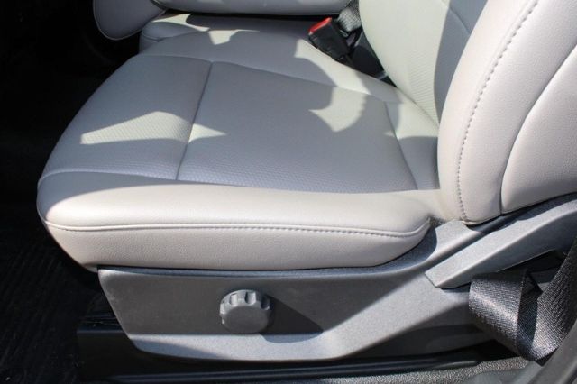 Ford F-250 front seats with light gray upholstery and manual seat adjustment knob.