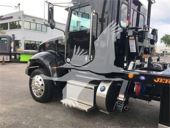 Peterbilt 337 tow truck side view with stepside and chrome fuel tank, front fender, and wheel. Visible labels and blue circular decals on the door; orange warning lights near wheel well.