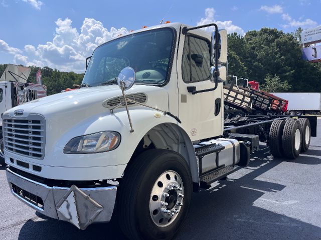 2015 Freightliner M2 cab and chassis truck with white paint, front grille, large side mirrors, and dual rear axles.