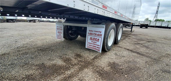 Vanguard MAXCUBE dry van trailer undercarriage with dual rear axles and signage on the ground listing 1-888-736-4826 LOCA.