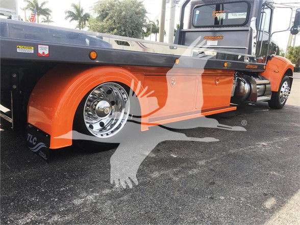 2022 Peterbilt 337 tow truck side view showing orange lower body panels and chrome wheels.