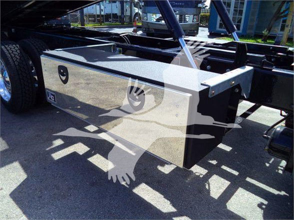 Kenworth T880 chassis showing side toolbox and frame components in a dealership lot.