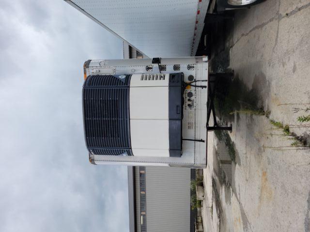 Front of a refrigerated trailer with a refrigeration unit at the front, visible black grille and white body. No legible text or model numbers clearly readable."